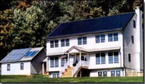 Conventional photovoltaic (PV) panels (and solar hot water panels) are mounted on the garage. Thin-film PV modules virtually disappear on top of the house's metal roof.